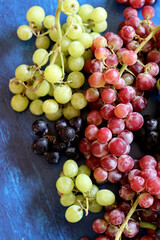 Black, green and red grapes on close up.  Top view photo of seasonal fruits. Healthy eating concept. 