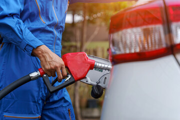 Close up man hands refueling a white car. higher oil prices.