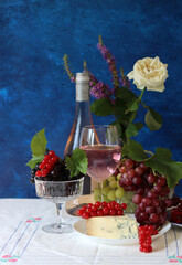 Still life with wine and grapes. Colorful photo of bottle of rose wine and different sorts of...