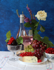 Still life with wine and grapes. Colorful photo of bottle of rose wine and different sorts of...