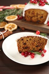Fototapeta na wymiar Traditional classic Christmas cake decorated with cranberries and rosemary on wooden table
