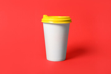 Takeaway paper coffee cup on red background