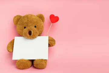 Fotobehang Cute teddy bear with red heart and blank card on pink background, space for text. Valentine's day celebration © New Africa