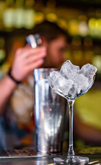 Ice cube in an empty glass on a bar counter in bar or pub