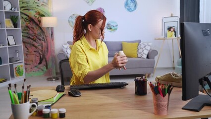 shoe design, young creative woman with sneakers in her hands is looking at how to refresh shoe design while sitting in modern apartment