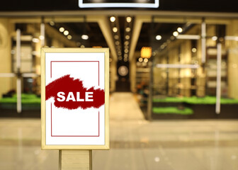 Advertising board with text SALE in shopping mall. Special promotion