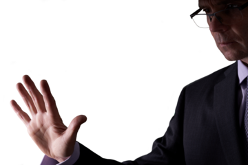 A cutout of a businessman holding out his hand as if placing it on a screen to be scanned in a low light room. A design element for use with composite imagery