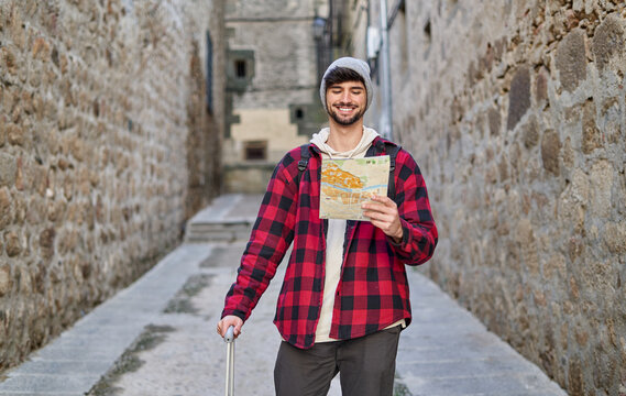 Traveling man with suitcase checking map