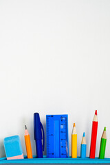 School stationery set sticking out of the pencil case at the bottom of the page white background, top, middle, sides free for ad text, good vertical or horizontal photo, close-up, eye level, top view 