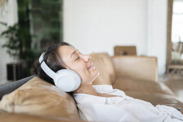 A female freelancer listens to calm music with headphones using a new app, balance and harmony
