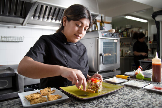 Hispanic chef serving crouton near tuna tartare