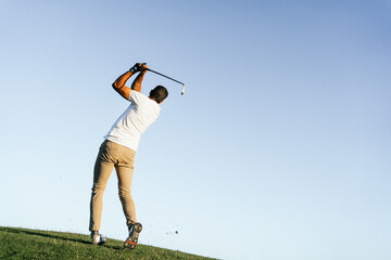 Golfer playing golf on course in countryside