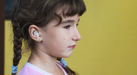 Girl with a warming therapeutic cotton swab in the ear with a sad and tearful face is holding her ear. Ear pain, otitis media, swelling of cheek, gums, toothache, children's surgery, otolaryngology