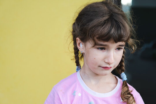 Girl With A Warming Therapeutic Cotton Swab In The Ear With A Sad And Tearful Face Is Holding Her Ear. Ear Pain, Otitis Media, Swelling Of Cheek, Gums, Toothache, Children's Surgery, Otolaryngology