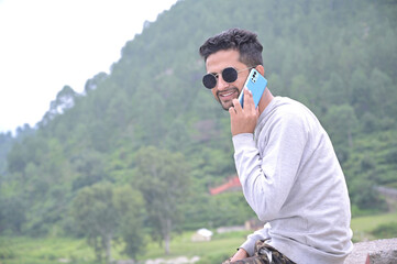 a yong tourist boy sudden captured while communicate by mobile phone in forest.