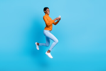 Full size profile side photo of nonbinary trans person jumping up chatting with friends isolated on blue color background