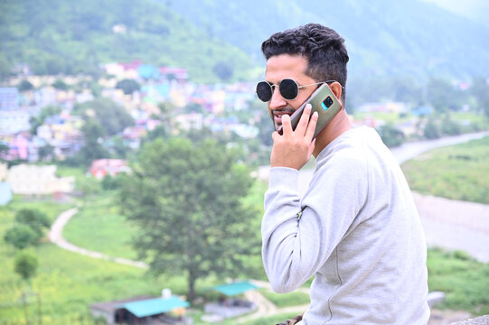 a man talks on the phone around the nature.