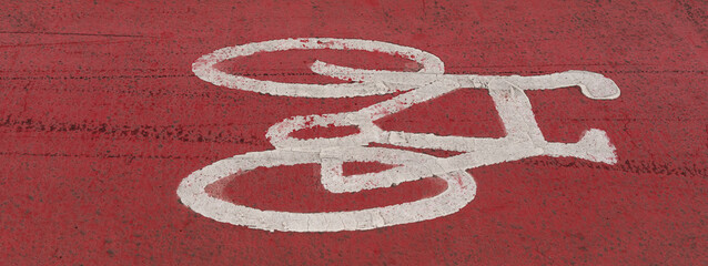 Plymouth, Devon, England, UK. 2022. White painted bicycle on red coloured road surface along a city road and cycleway.