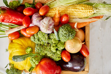 Wooden box with different fresh farm vegetables on the white background, Autumn harvest and healthy organic bio food concept, Garden produce and harvested vegetable