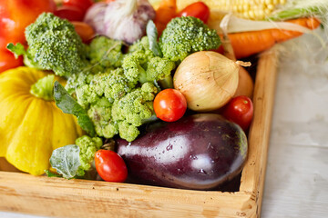 Wooden box with different fresh farm vegetables on the white background, Autumn harvest and healthy...