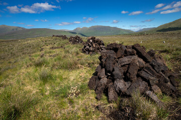 vue sur une tourbière en Irlande Des briques de tourbe sont empilées dans un champ de tourbe - obrazy, fototapety, plakaty
