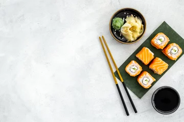 Fotobehang Sushi rolls set with salmon eco served on green papper plate, top view © 9dreamstudio