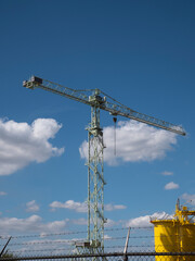 Large industrial crane with iron stairs and a blue cloudy sky