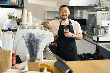 Radiant bearded man working at espresso bar