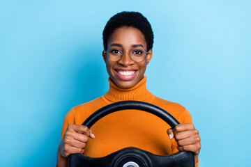 Photo of positive charming driver lady hold steering wheel wear yellow turtleneck isolated blue color background