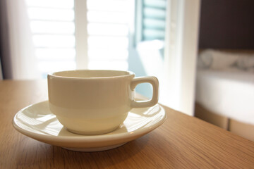 A cup of coffee on the table in the bedroom.