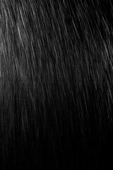 黒い背景に雨が降る