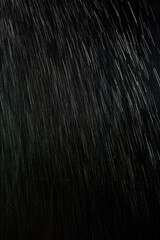 黒い背景に雨が降る