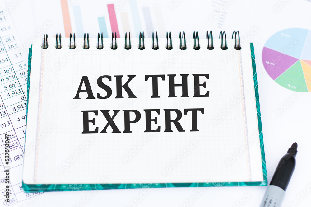Poster ask the expert text on a notepad on the table next to reports and diagrams, a business concept