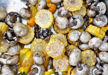 Raw grilled vegetables on a metal tray. Corn, mushrooms and peppers ready for frying