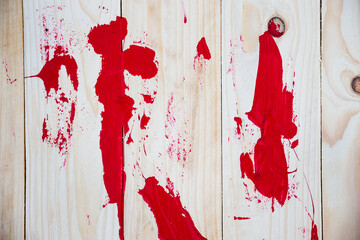 Red paint on wooden background