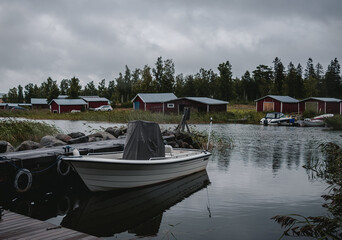 Obraz premium fishing boats and wooden red huts. view of the lake.
