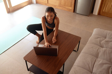 Yoga At Home. Woman Preparing Training with Laptop. Young Female Sitting On Floor And Going To Practice. Sport Routine For Staying Calm