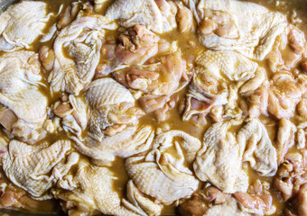Many raw piece of fresh chicken meat in marinade ready to cooking barbecue close-up
