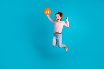 Full body photo of crazy excited pupil hold balloon jumping raise fist isolated on blue color background