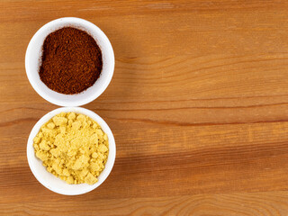 Yellow mustard and red Chilli powder in White bowls on a table background