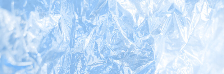 Obraz premium Iridescent foil texture background. Holographic wrinkled surface. Vibrant blue gradient template for design. Banner with copy space