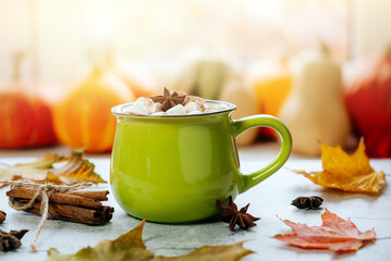Cozy autumn hot drink with marshmallow and yellow maple leaves