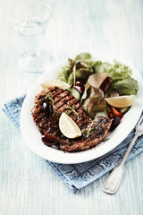 Grilled pork steak with fresh salad. Bright wooden background.	