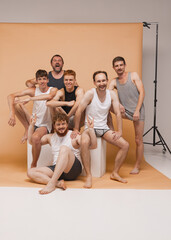 Fototapeta na wymiar Six young men of different ages having photo shoot at studio. Feeling happy, cheerful and comfortable. Concept of body positive, fashion, friendship
