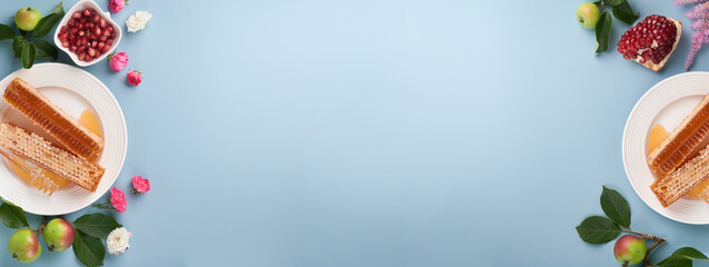 Rosh Hashanah. Honey jar, honeycomb, apple and pomegranate on simple blue background. Jewish New Year holiday greeting card. Rosh Hashanah holiday attributes. Space for text. Banner.