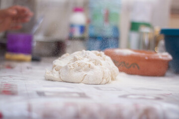 a woman kneading natural dough with white flour by hand
