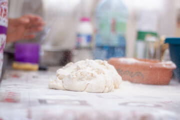 a woman kneading natural dough with white flour by hand
