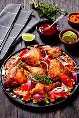 roast chicken with corn and tomatoes on plate
