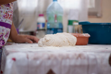 a woman kneading natural dough with white flour by hand