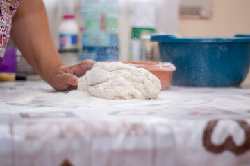 a woman kneading natural dough with white flour by hand